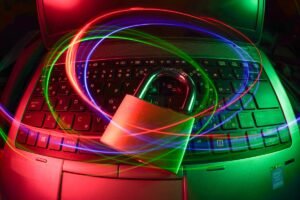 Um cadeado fica em um teclado de laptop com trilhas de luz coloridas girando acima, simbolizando a segurança cibernética ou a proteção de dados.