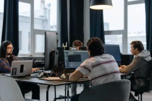 Equipe de TI trabalhando em escritorio com multiplos monitores