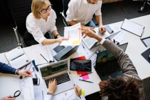 Equipe colaborando em escritorio moderno com laptops e documentos